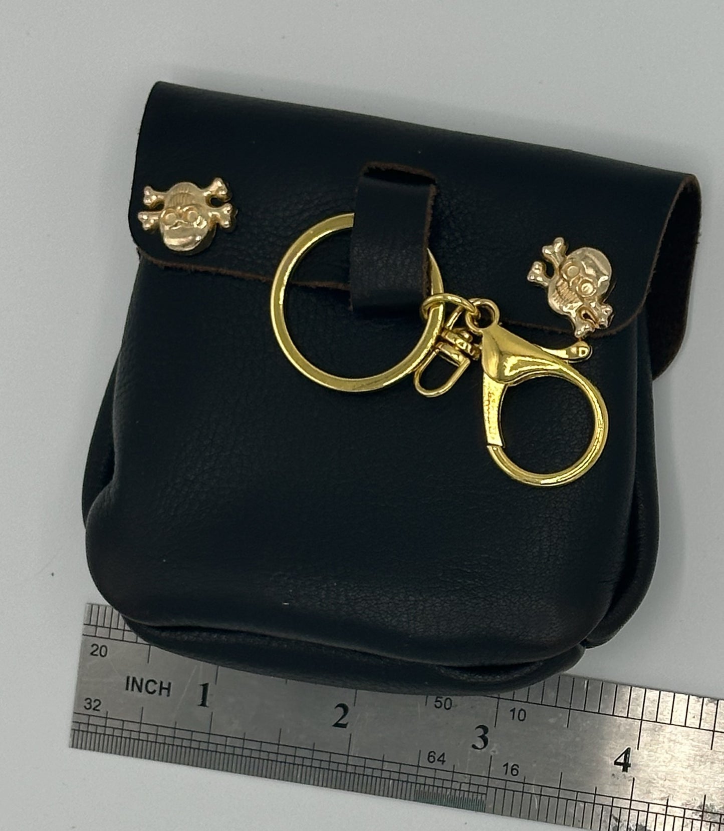 Dark brown leather pouch with skull rivets